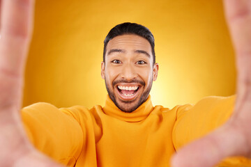 Excited, portrait and selfie of man in studio isolated on a yellow background. Face, smile and Asian person taking profile picture for happy memory, funny or influencer laughing for social media post