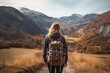 A woman with a backpack walks along the path in the mountains. A female hiker walking to mountains rear view, AI Generated