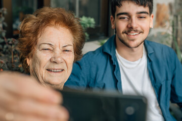 grandmother making a selfie with mobile phone with her grandson