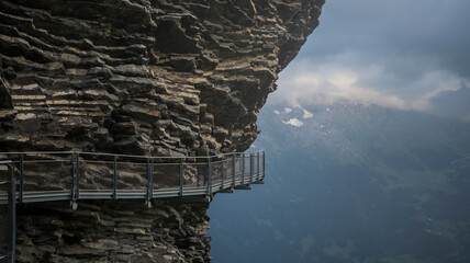 Evening view on the first cliff walk perched to the side of the mountain in Grindelwald, Switzerland. Alpine landscape with  in the background. Bad weather coming soon.