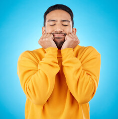 Leinwandbilder - Man, shy and touching cheeks in studio isolated on a blue background. Peace, calm and person in love, relax for zen and meditation, content and satisfied with eyes closed, hands on face and wellness