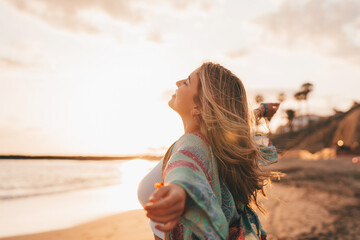 Wall Mural - Portrait of one young woman at the beach with openened arms enjoying free time and freedom outdoors. Having fun relaxing and living happy moments..