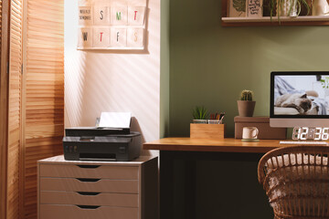 Poster - Stylish workplace with computer, printer and houseplant near olive wall at home