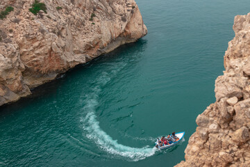a view from above of a boat touring between two large rocky mountains in one of the beaches of the c