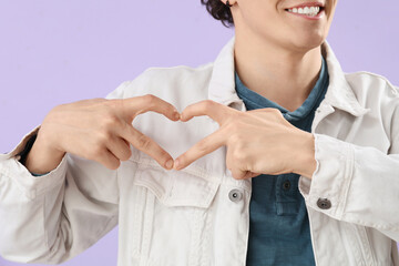 Sticker - Young man making heart with his hands on lilac background, closeup