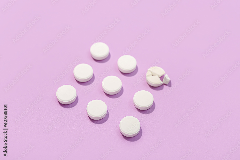 White pills on lilac background
