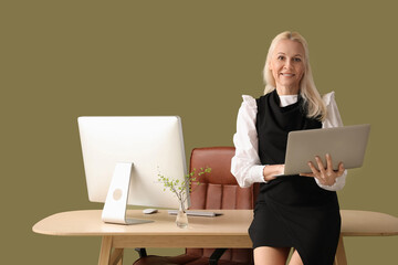 Poster - Mature female programmer working with laptop on green background