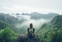 Back View Of A Young Woman Observing Mountains Covered With Tropical Forest, Low Clouds And Fog In The Valley