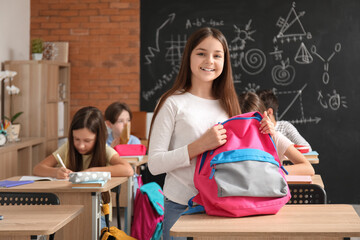 Wall Mural - Little girl with backpack in classroom