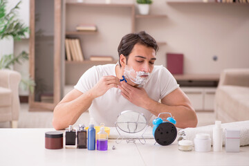 Wall Mural - Young man shaving face at home