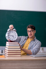 Wall Mural - Young male student in time management concept