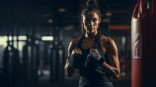 Striking Image Of A Female Boxer At Work In A Dimly Lit Gym - A Vivid Portrayal Of Determination And Power