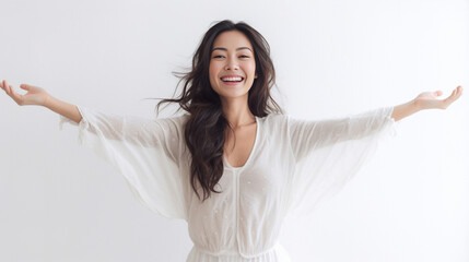 a beaming lady in a white t-shirt dress raises her arms with a relaxed smile, expressing her unbridl