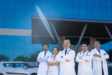 Wall Mural - Successful team of medical doctors standing out of hospital.