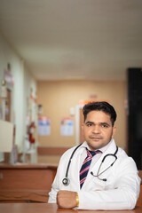 Poster - Young indian doctor standing at hospital.