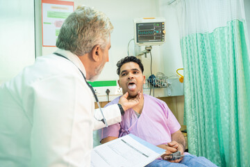 Wall Mural - Doctor checking patient tongue between medical examination at hospital.