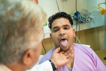 Wall Mural - Doctor checking patient tongue between medical examination at hospital.