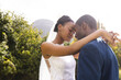 Happy african american bride and groom embracing at wedding in sunny garden