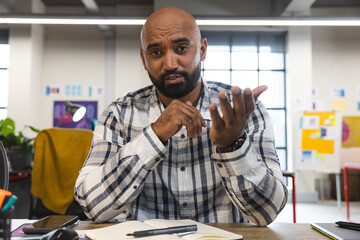 Fototapete - Indian man talking looking at the camera during a video call at office