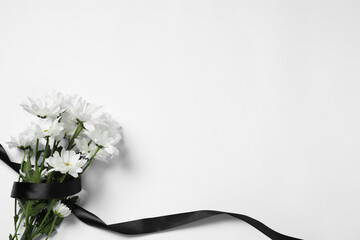 Beautiful chrysanthemum flowers and black ribbon on white background, top view with space for text. Funeral symbols