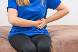 Kobieta pokazująca ból brzucha z lewej strony ciała 