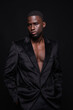 © ADDICTIVE STOCK - Black man in coat standing against black background