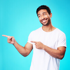 Poster - Mockup, pointing and man with a smile, thinking and choice against a blue studio background. Male person, decision or model with product placement, hand gesture and presentation with sign and showing