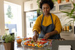 © Wavebreak Media - Happy plus size african american woman in apron preparing meal in kitchen