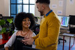 © Wavebreak Media - Diverse man and woman discussing over a digital tablet at office
