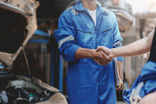 Auto Mechanic Handshake Successful Colleague In Auto Service Center To Congratulate The Success Of Car Maintenance. Professional Car Mechanic Shaking Hands.