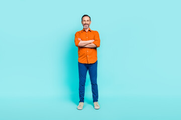 Sticker - Full length photo of cute positive guy wear orange shirt arms folded isolated teal color background