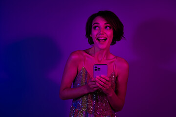 Poster - Photo of positive surprised lady browsing festive events ads in nightclub using cell gadget isolated colorful neon background