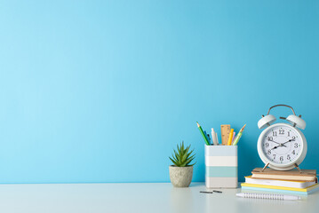 Sticker - Promote a productive study environment with side-angle photo featuring white desk, alarm clock, notepads, penholder, and office supplies on blue backdrop, providing ample copy-space for text or ads