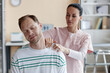 © AnnaStills - Young woman doing massage to patient during his visit to hospital