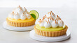 Key lime pie and lemon meringue tart on a pure white surface