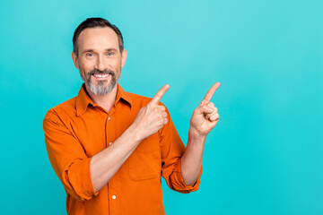 Photo of cheerful man with white gray beard wear stylish shirt indicating at proposition empty space isolated on teal color background
