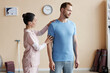 © AnnaStills - Professional therapist examining shoulder and back of patient in hospital
