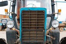 Retro Blue Old Farm Tractor Outdoors, Close-up Of Grate With Headlights, Front View