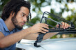 © auremar - man is isntalling a car roof rack