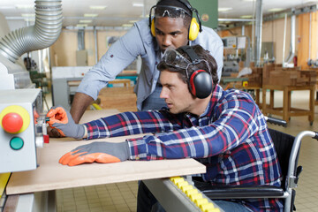 Wall Mural - manager and disabled worker in wheelchair in factory