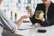 © Wasan - Businesswoman real estate agent hands over the house keys to a homebuyer after the purchase agreement has been signed.