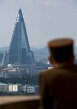 North Korean Soldier Watching Ryugyong Hotel From The Juche Tower, Pyongan Province, Pyongyang, North Korea