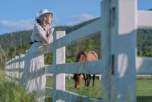 Pretty Asian Women In Ancient-style Costumes Stand By The White Fence Of Stables Relax Happily Together. Vintage Blouse Costume. Historical Dresses, Victorian Or Edwardian Era Style Dress.