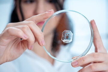 Wall Mural - young woman laboratory assistant examines a sample of 3D bioprinting p