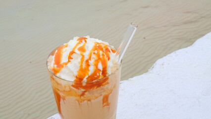 Refreshing frappuccino with caramel in ocean close up. Cinematic video refreshing frappuccino with caramel on vacation in ocean Concept enjoy delicious refreshing caramel frappuccino and swim in ocean