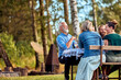 © Flamingo Images - Man laughing with family outside at a table