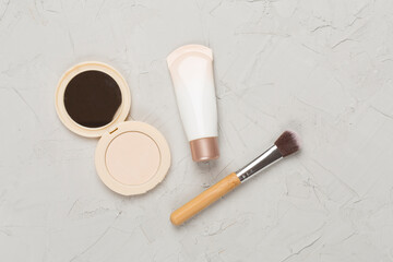 Composition with makeup products for skin tone on concrete background, top view