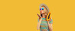 Summer portrait of stylish young woman with fresh juicy papaya blowing her lips sending air kiss wearing straw hat, sunglasses posing on yellow background, blank copy space for advertising text