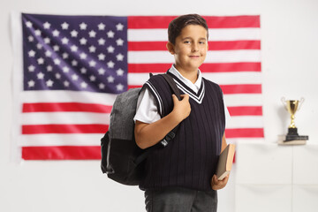 Poster - Boy school uniform holding a book and carrying a backpack in front of USA flag