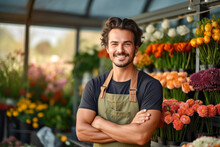 A Handsome Young Male Florist Gardener Posing In Greenhouse. Small Business Owner In Flower Shop